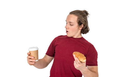 Young handsome man drink coffee and eating croissant. French breakfast and morning coffeeの写真素材