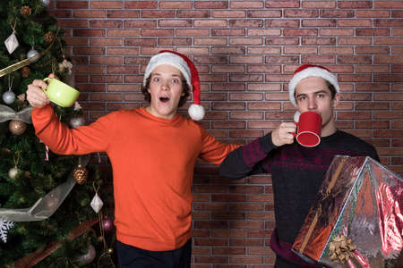 Two funny young men celebrating christmas