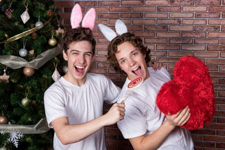 Two funny guys in suits rabbits celebrating christmas over brick wallの写真素材