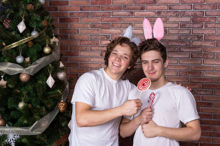 Two funny guys in suits rabbits celebrating christmas over brick wall
