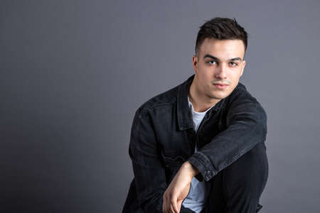 Young serious man posing in studioの写真素材