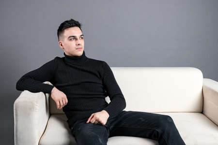 Young serious man posing in studioの写真素材