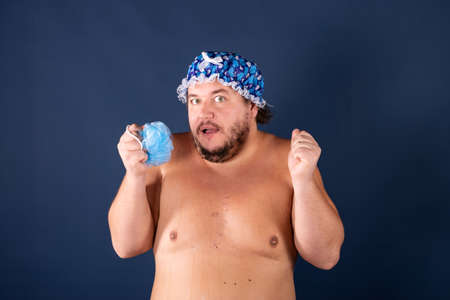 Funny fat man in blue cap sing in the showerの写真素材