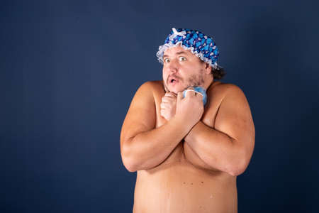 Funny fat man in blue cap sing in the showerの写真素材