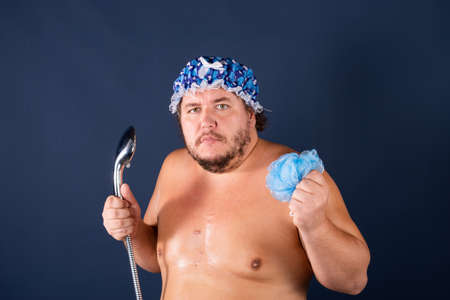 Funny fat man in blue cap sing in the showerの写真素材