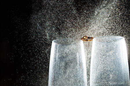 Gold wedding rings with water splashesの写真素材