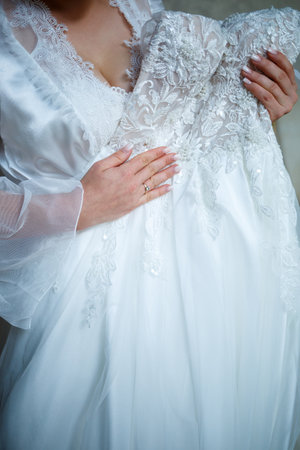 the bride holds in her hands a beautiful wedding dressの写真素材