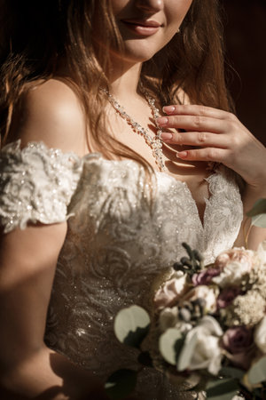 Beautiful bride holding a delicate bouquet of flowers in her hands on a wedding dayの写真素材