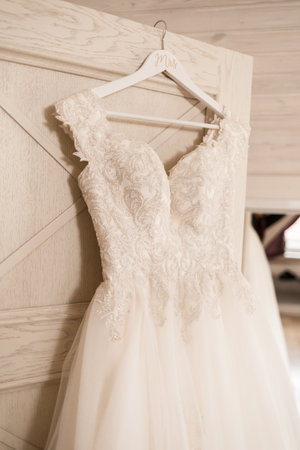 Ivory lace wedding long dress hanging on a wooden hangerの写真素材