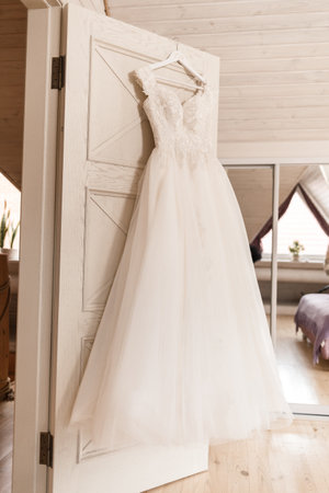 Ivory lace wedding long dress hanging on a wooden hangerの写真素材