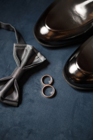 gold wedding rings on the wedding day for the newlyweds. Groom's accessories. Leather shoes for menの写真素材