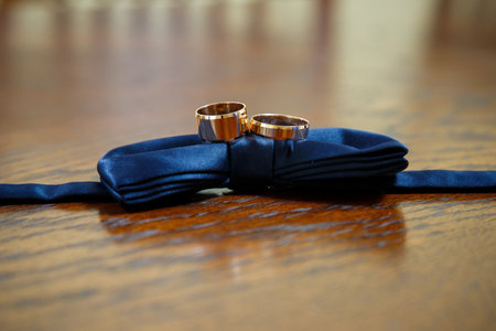 gold wedding rings lie on a man's bow tieの写真素材