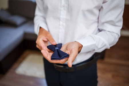 Young male businessman puts on a shirt and a stylish suit before a meeting