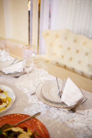Serving a festive table in a restaurant. Preparation of a banquet for a holiday. Expensive decoration materials. Dishes for food and drinksの写真素材