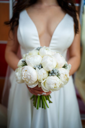 Beautiful wedding bouquet of flowers in the hands of the newlywedsの写真素材