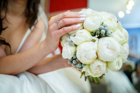 Beautiful wedding bouquet of flowers in the hands of the newlywedsの写真素材