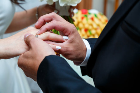 gold wedding rings in the hands of the newlywedsの写真素材