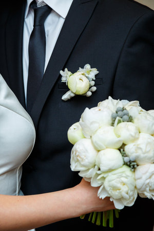 Beautiful wedding bouquet of flowers in the hands of the newlywedsの写真素材