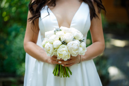 Beautiful wedding bouquet of flowers in the hands of the newlywedsの写真素材