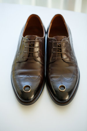 gold wedding rings on the wedding day for the newlyweds. Groom's accessories. Leather shoes for menの写真素材