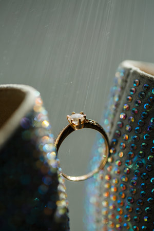 Gold ring of the bride with a pebble between white shoes with heels. Bride's precious ringの写真素材