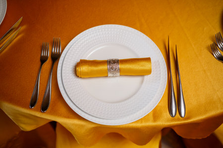 Elegant table setting with fork, knife and gold napkin