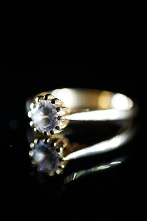 Gold wedding ring on black glassの写真素材