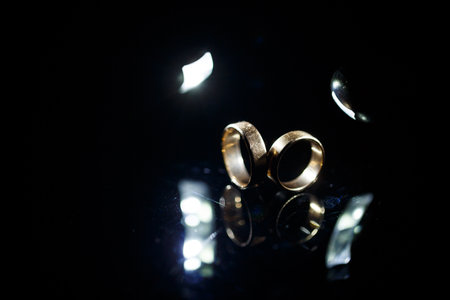 Gold wedding ring on black glassの写真素材