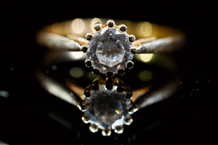 Gold wedding ring on black glassの写真素材