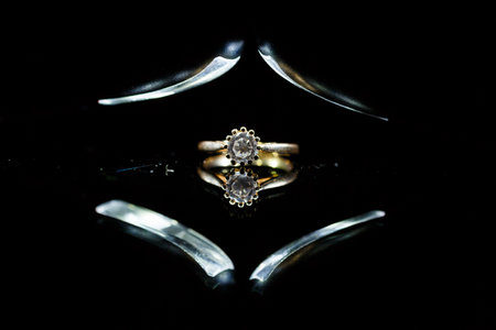 Gold wedding ring on black glassの写真素材