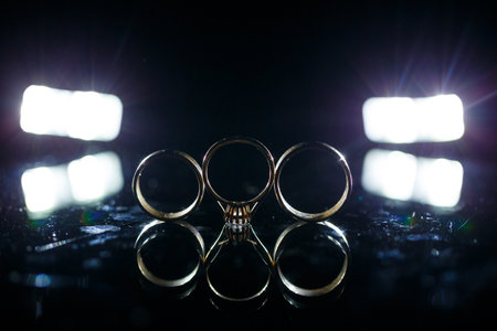 Gold wedding ring on black glassの写真素材