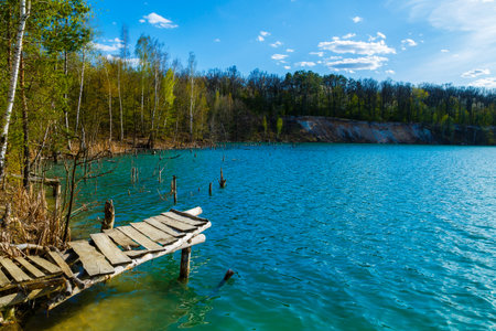 Wooden masonry stands on the water isolated. Entry into the lake from a wooden bridge into the lakeの写真素材