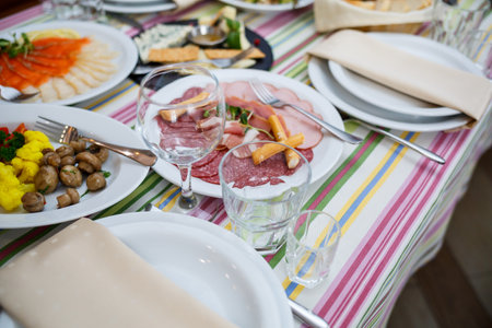 Table in the restaurant, dishes in white plates, festive banquetの写真素材