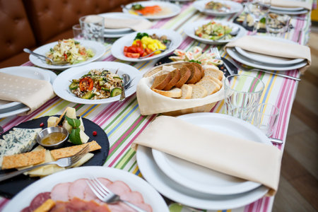 Table in the restaurant, dishes in white plates, festive banquetの写真素材