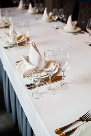 Serving a festive table in a restaurant. Preparation of a banquet for a holiday. Expensive decoration materials. Dishes for food and drinksの写真素材