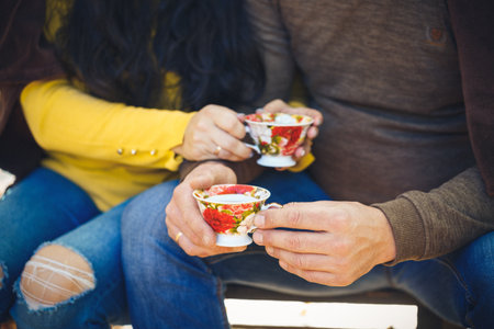 people, season, love, drinks and leisure concept - happy couple holding hot tea cups over winter landscapeの写真素材