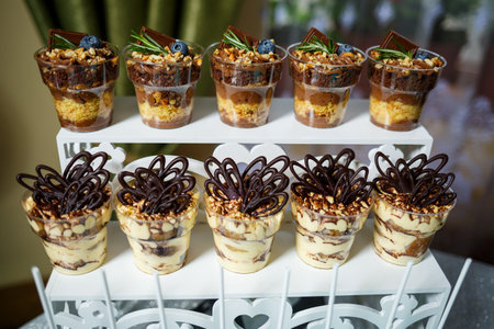 Beautifully decorated sweet buffet table on which cakes, muffins, marshmallows, pecans. Dessert table for a party, goodies for the wedding. Close up. Candy bar. A buffet for a weddingの写真素材