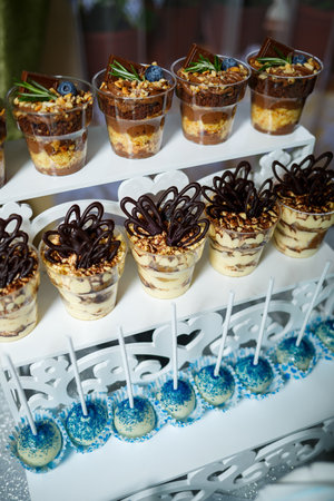 Beautifully decorated sweet buffet table on which cakes, muffins, marshmallows, pecans. Dessert table for a party, goodies for the wedding. Close up. Candy bar. A buffet for a weddingの写真素材
