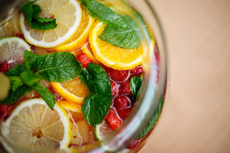 Refreshing lemonade with fresh fruit orange lemon cherry and mint leaves. Delicious non-alcoholic fruit cocktail in a jugの写真素材