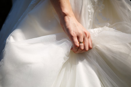 gold wedding rings in the hands of the newlyweds