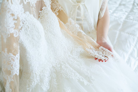 the bride holds in her hands a beautiful wedding dress