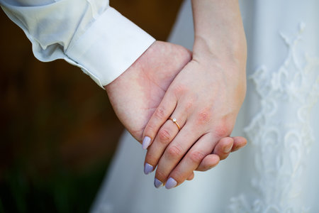 gold wedding rings in the hands of the newlywedsの写真素材
