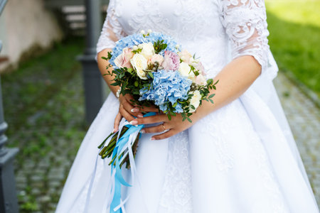 Beautiful wedding bouquet of flowers in the hands of the newlywedsの写真素材