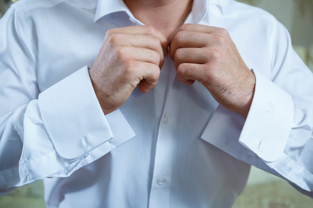 A man puts on a men's suit on the day of the weddingの写真素材