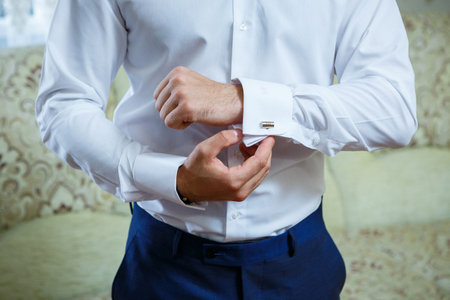 A man puts on a men's suit on the day of the weddingの写真素材