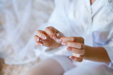 gold wedding rings in hands of newlyweds on wedding dayの写真素材