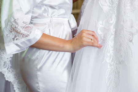 the bride holds in her hands a beautiful wedding dressの写真素材