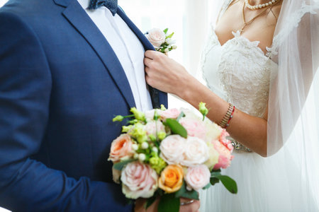 Beautiful wedding bouquet of flowers in the hands of the newlywedsの写真素材