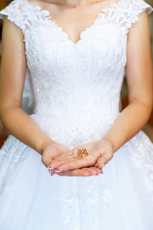 gold wedding rings in hands of newlyweds on wedding dayの写真素材