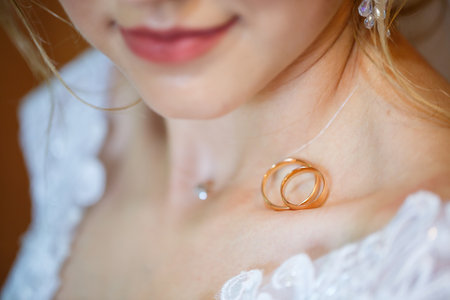 gold wedding rings in hands of newlyweds on wedding dayの写真素材